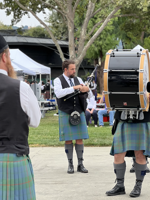 Jon Barclay playing bagpipes in traditional Scottish highland dress